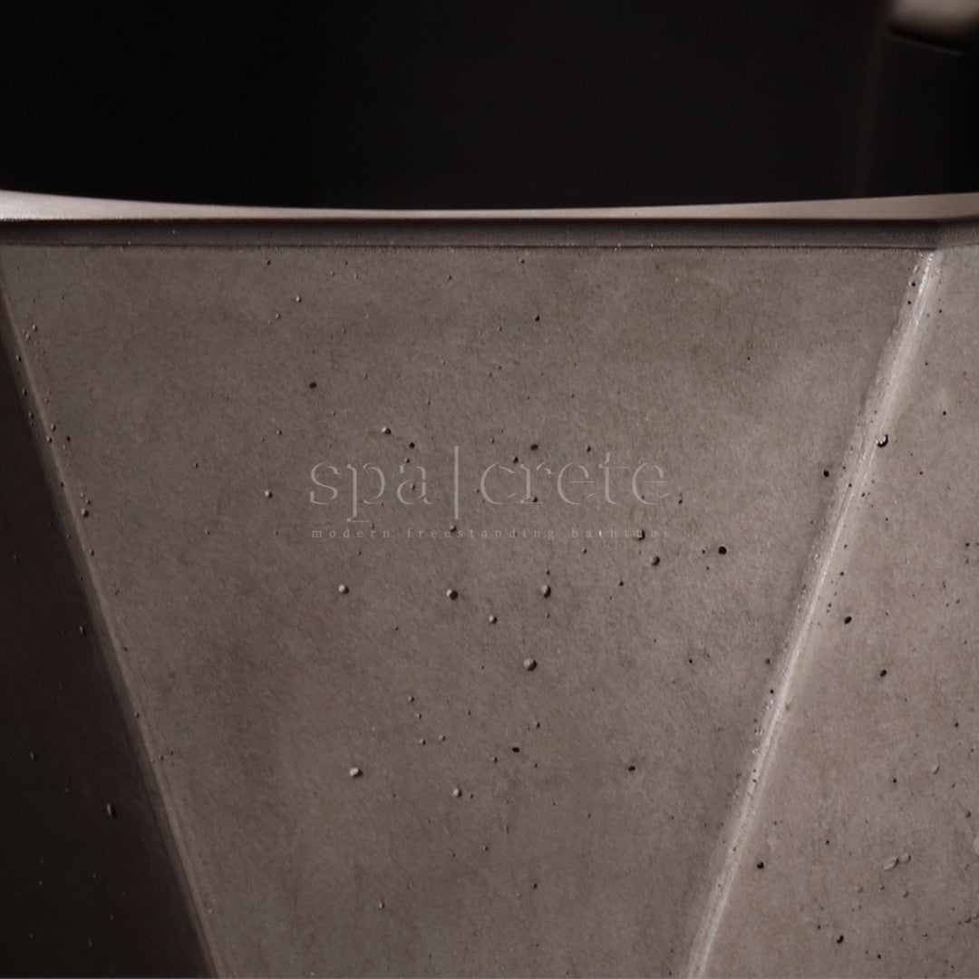 
                      Close-up of Quintessential Voids finish and top rim in Industrial Grey on SpaCrete Geometric concrete bathtub
                     
