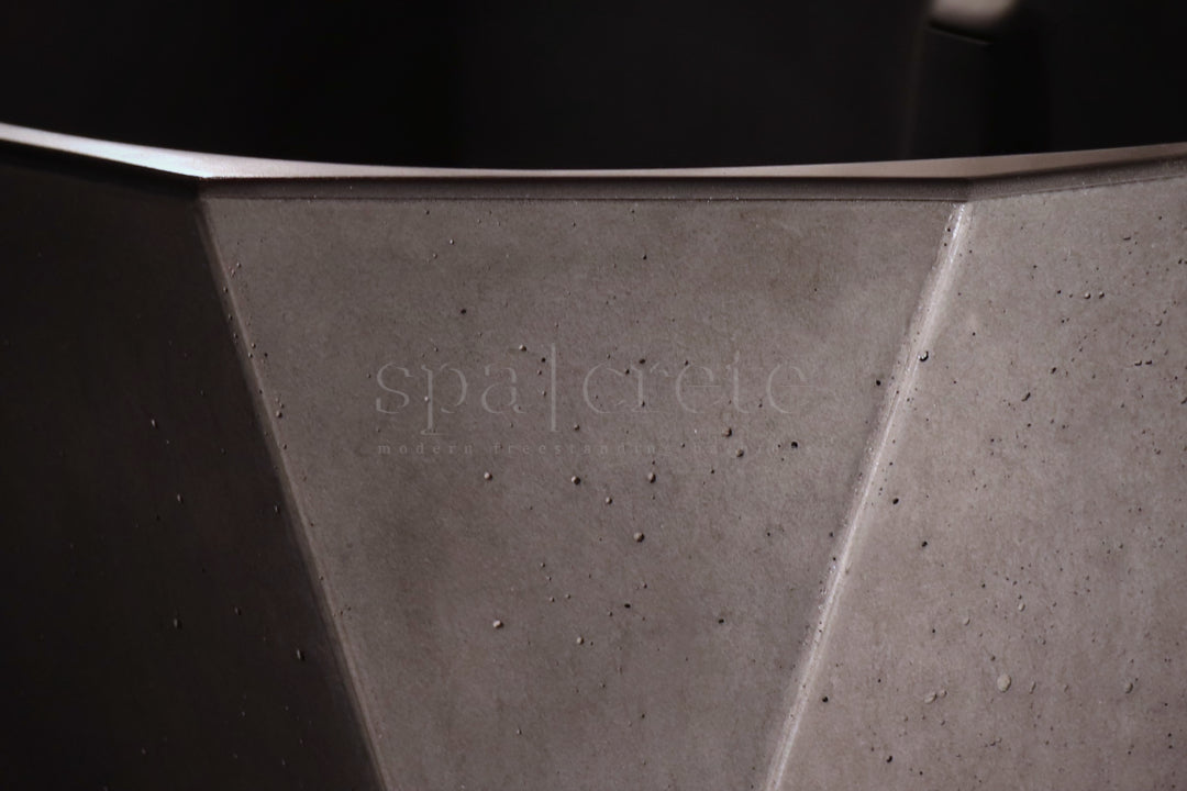 
                    
                     Close-up of Quintessential Voids finish in Industrial Grey on SpaCrete Geometric concrete bathtub
                    
                  
