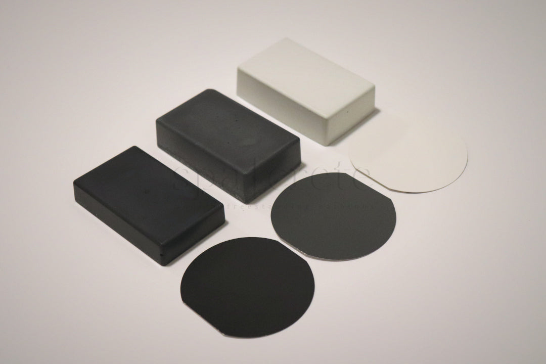 
                  
                   Three SpaCrete concrete color samples in titanium white, charcoal and industrial grey with matching paint chips
                  
                